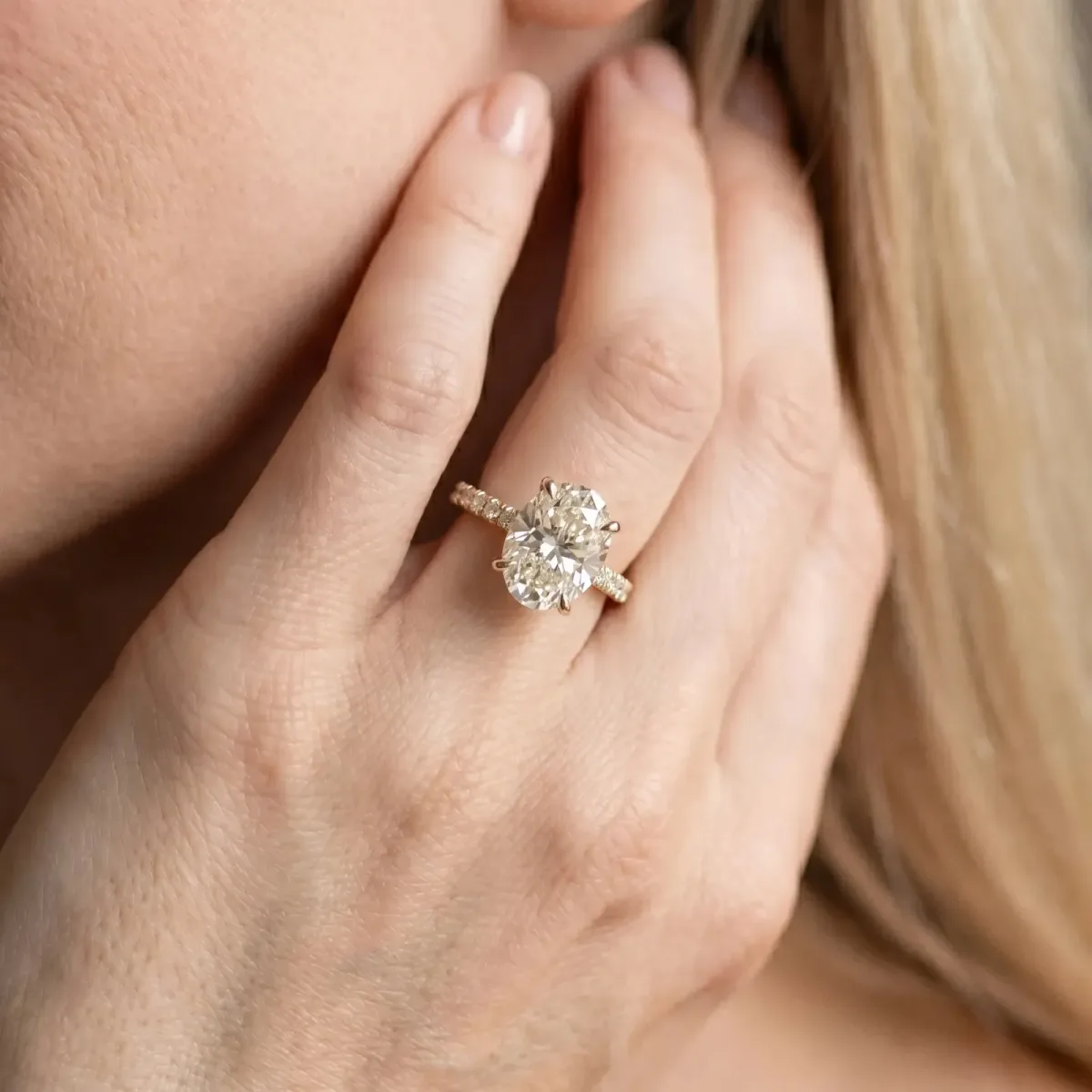 Oval Cut Diamond Solitaire Ring with Round Pavé Band and Prong Setting Yellow gold