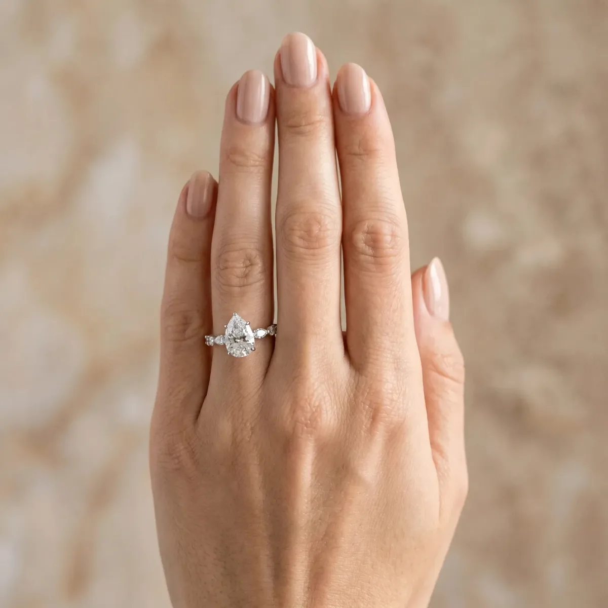 Pear Cut Diamond Ring with Marquise and Round Side Stones and Four-Prong Setting White gold