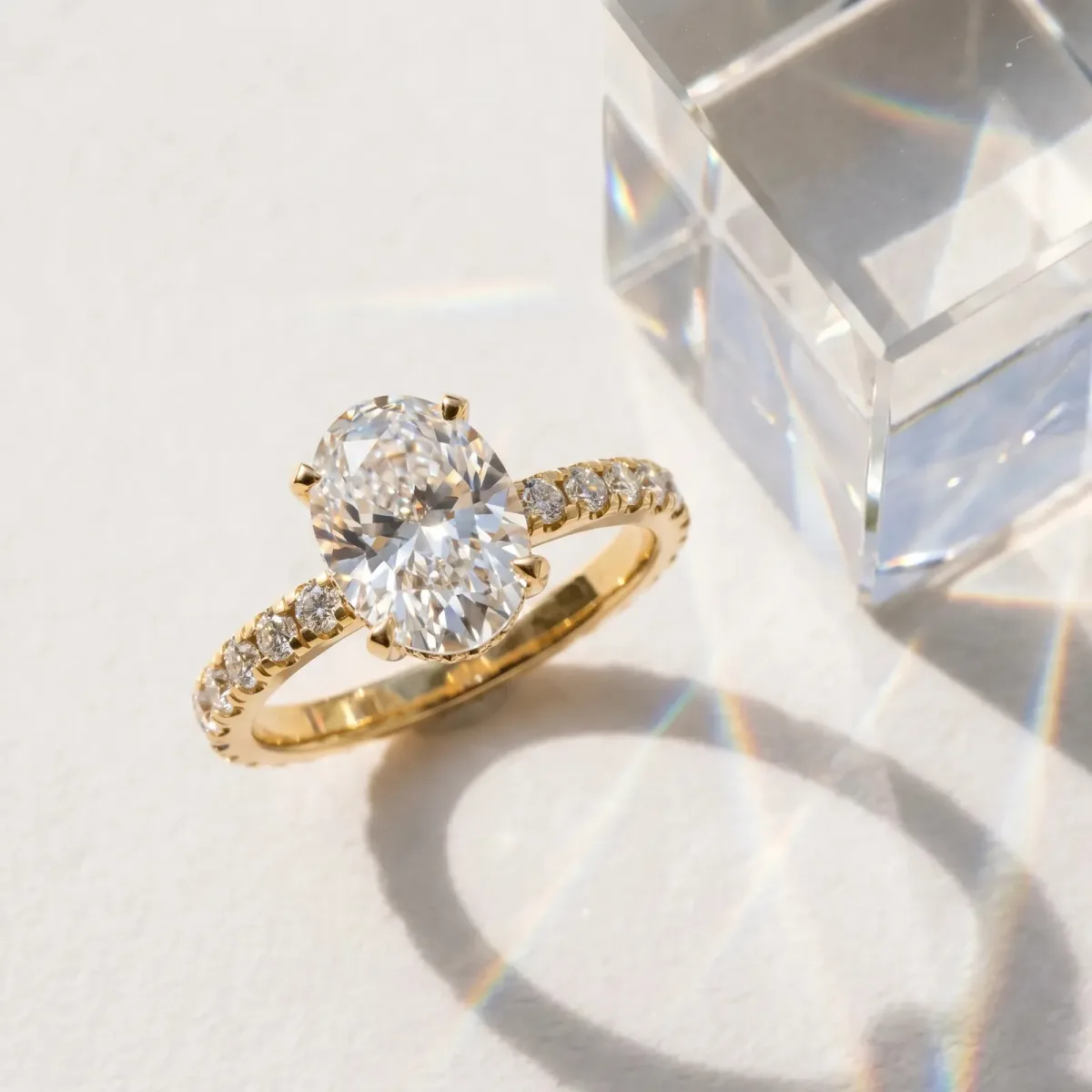 Oval Cut Diamond Solitaire Ring with Round Pavé Band and Four-Prong Setting Yellow gold