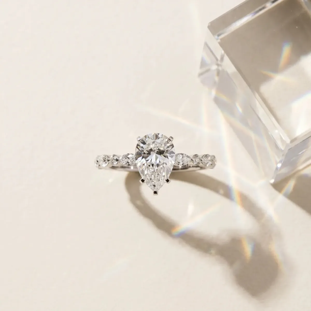 Pear Cut Diamond Ring with Marquise and Round Side Stones and Four-Prong Setting White gold