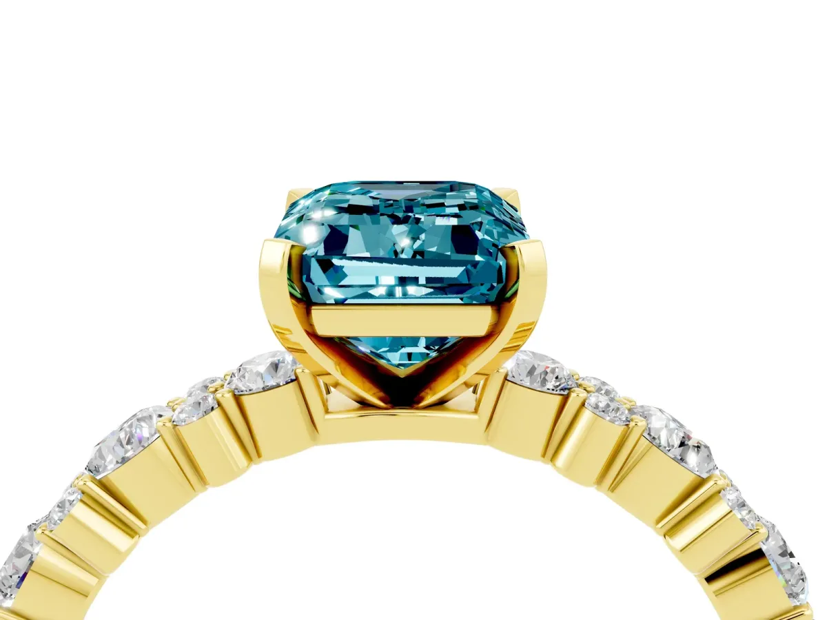 Emerald Cut Blue Topaz Side Stone Solitaire Ring with Round and Four-Prong Setting Yellow gold