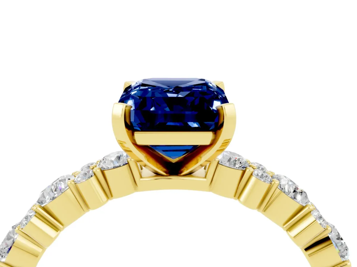 Emerald Cut Blue Sapphire Side Stone Solitaire Ring with Round and Four-Prong Setting Yellow gold