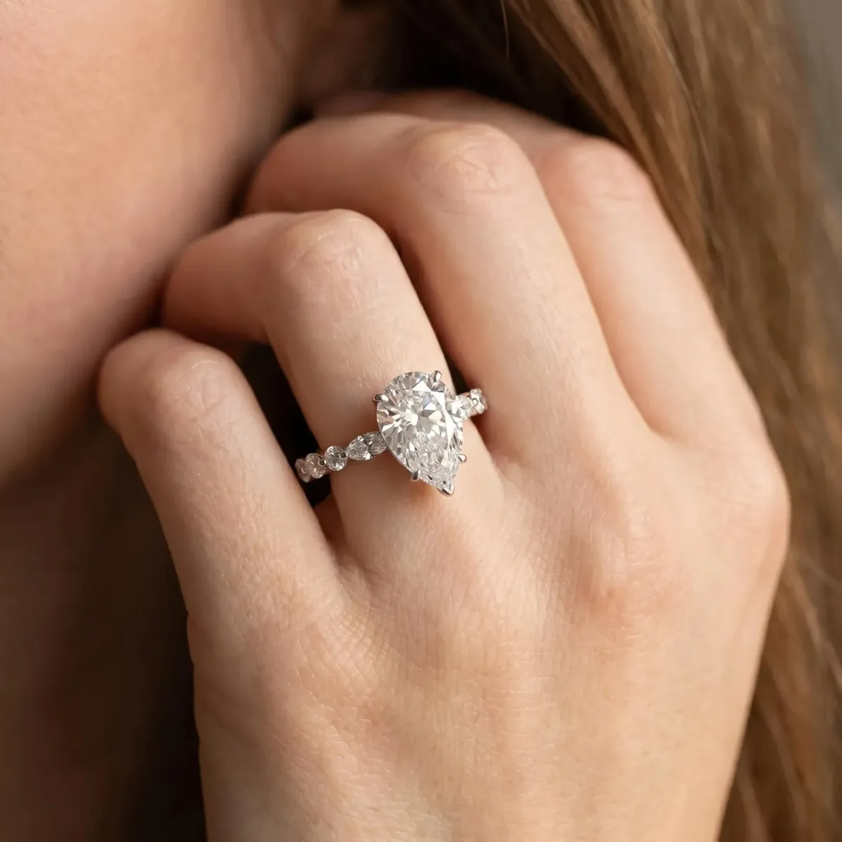 Pear Cut Diamond Ring with Marquise and Round Side Stones and Four-Prong Setting White gold