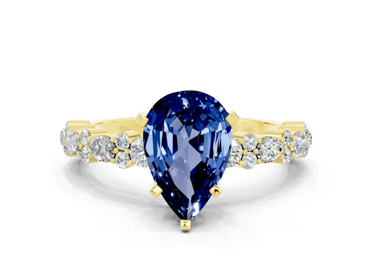 Pear Cut Blue Sapphire Side Stone Solitaire Ring with Round and Four-Prong Setting Yellow gold
