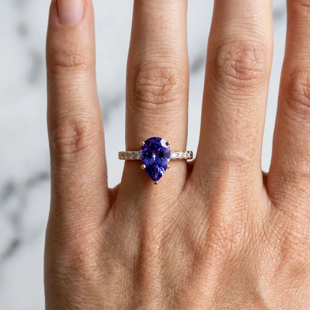 Pear Cut Tanzanite Solitaire Ring with Round Pavé Band and Four-Prong Setting Rose gold