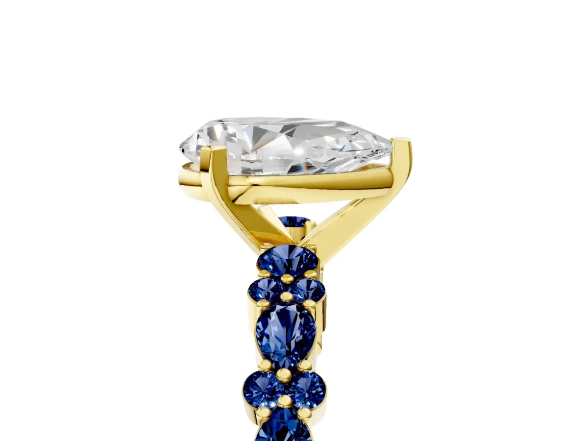 Pear Cut Diamond Side Stone Solitaire Ring with Round Blue Sapphire and Four-Prong Setting Yellow gold